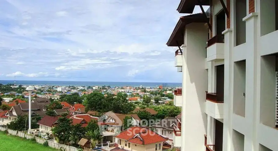 Stunning coastal view from modern apartment building overlooking vibrant neighborhood.