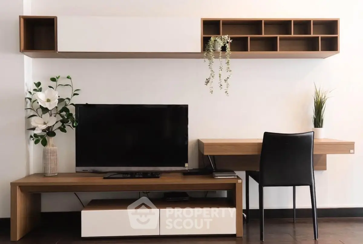 Modern living room with sleek TV stand, wall shelves, and stylish desk setup.