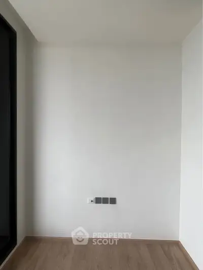 Minimalist interior with white walls and wooden flooring, perfect for customization.