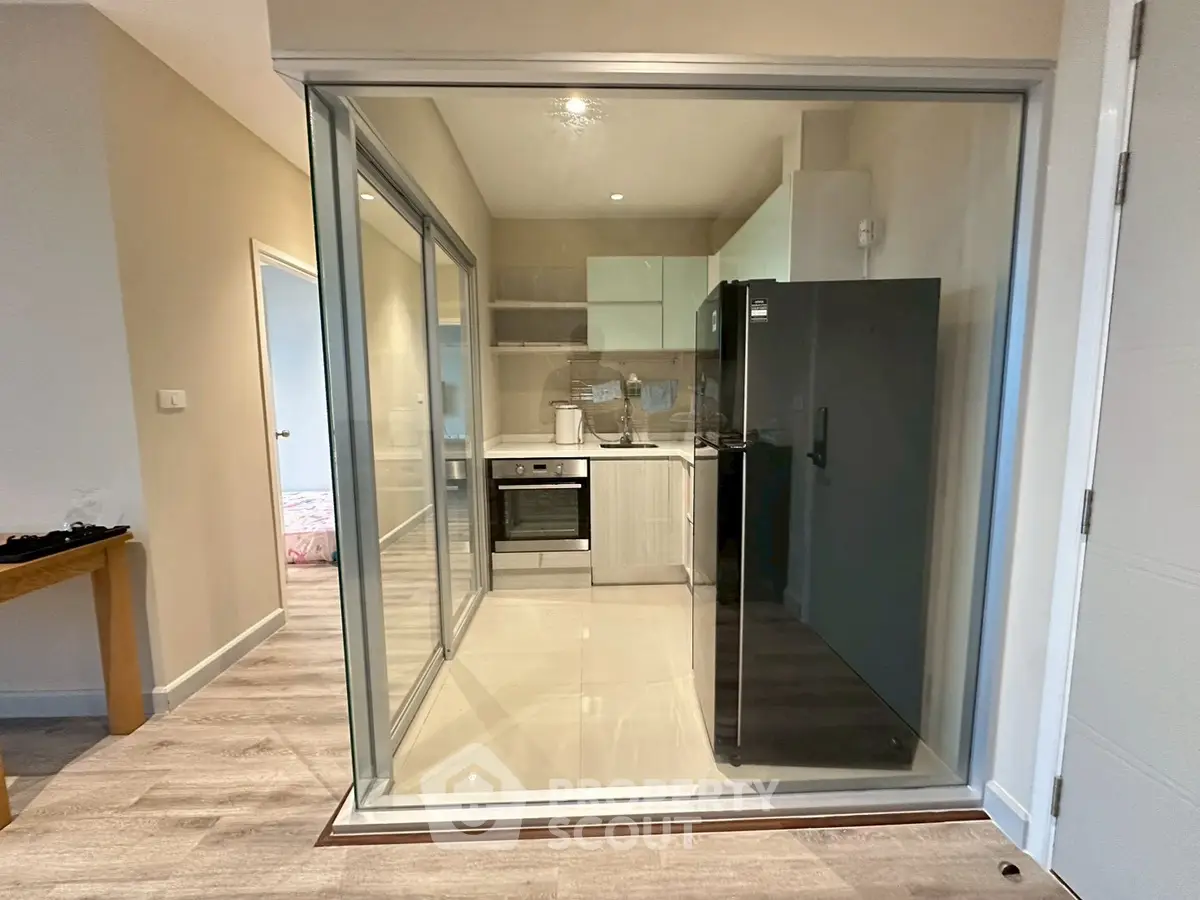 Modern kitchen with glass enclosure and sleek appliances in stylish apartment
