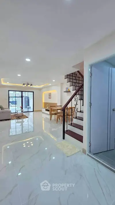 Modern open-plan living room with elegant staircase and stylish lighting