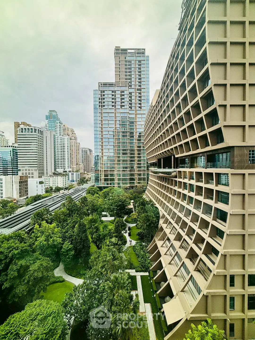 Stunning architectural view of modern high-rise buildings with lush green gardens in urban setting.