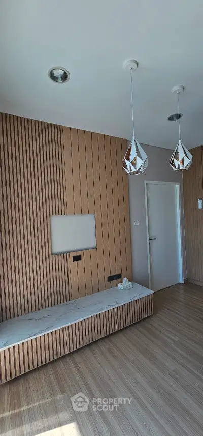 Modern living room with stylish wooden paneling and elegant pendant lights