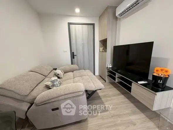 Modern living room with cozy sofa and sleek TV setup in a stylish apartment.