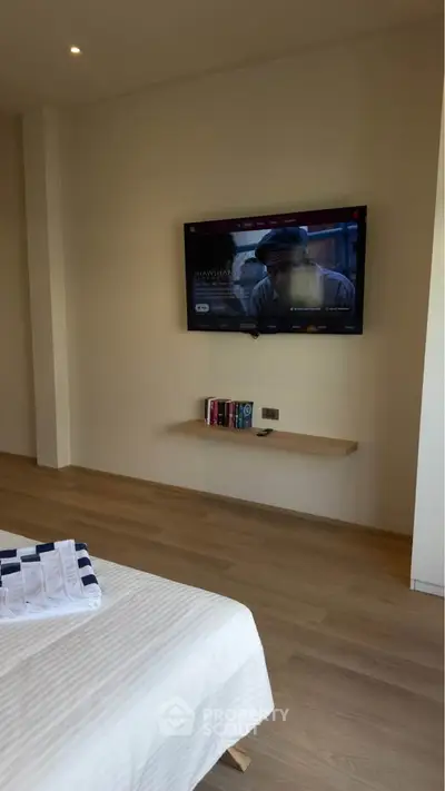Modern bedroom with wall-mounted TV and minimalist decor