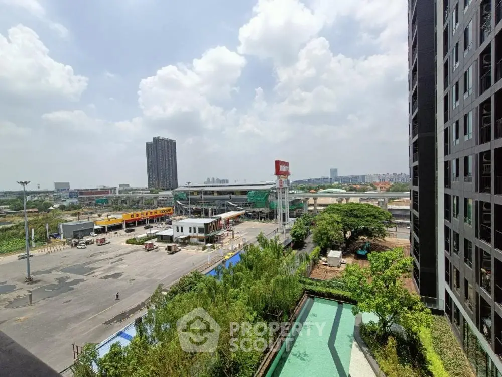 Stunning cityscape view from high-rise building with lush greenery and clear skies.