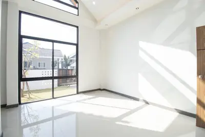 Bright and spacious empty room with large windows and garden view