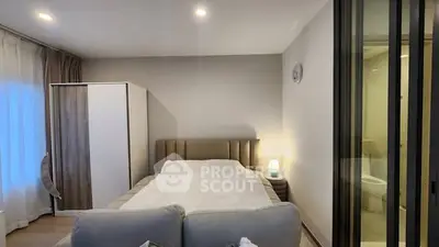 Cozy bedroom with modern decor and ensuite bathroom in stylish apartment.
