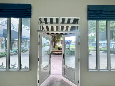 Inviting entrance with large windows and outdoor view, perfect for welcoming guests.