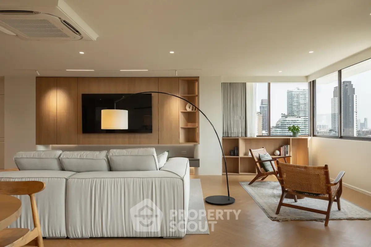 Spacious modern living room with city view, elegant furniture, and natural light.