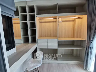 Modern study room with built-in wooden shelves and desk, featuring a stylish chair and natural light.