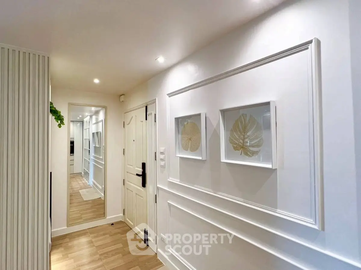 Elegant hallway with modern decor and wooden flooring in a stylish apartment.