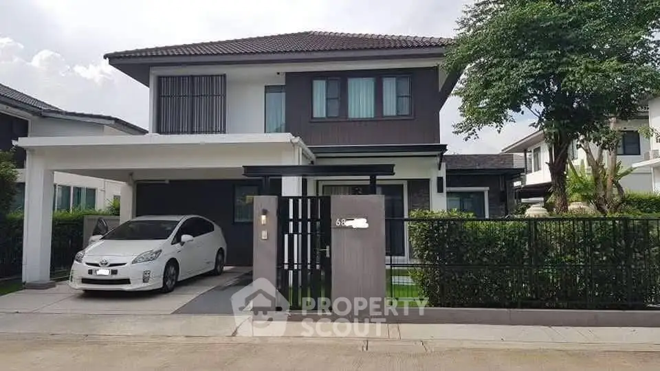 Modern two-story house with carport and landscaped front yard in a suburban neighborhood.