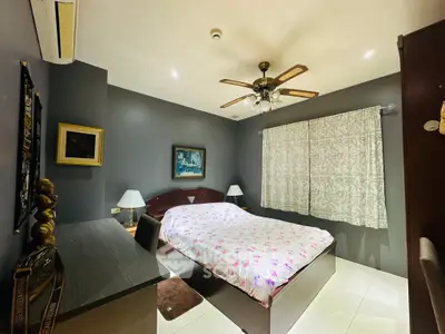 Cozy bedroom with elegant decor and ceiling fan, perfect for relaxation.