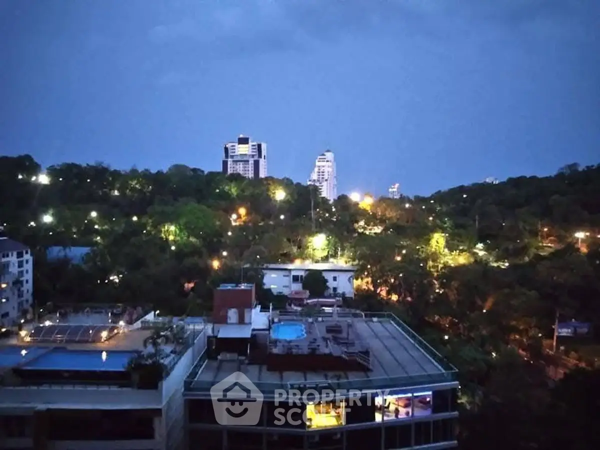 Stunning cityscape view with illuminated buildings and lush greenery at dusk.
