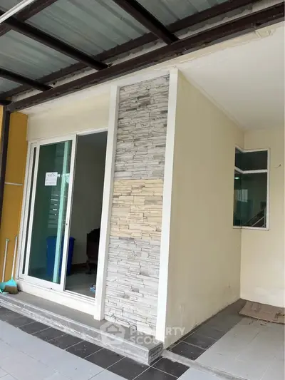 Modern exterior with sliding glass doors and stone accent wall