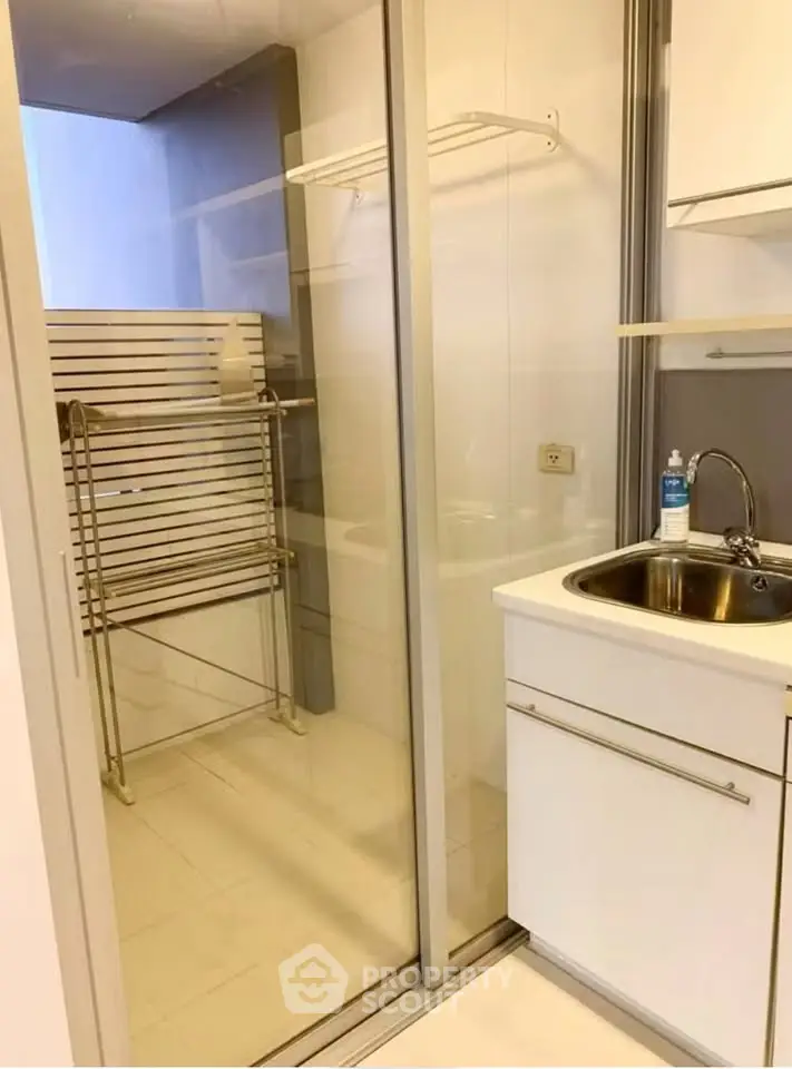 Compact bathroom with modern sink and glass shower enclosure