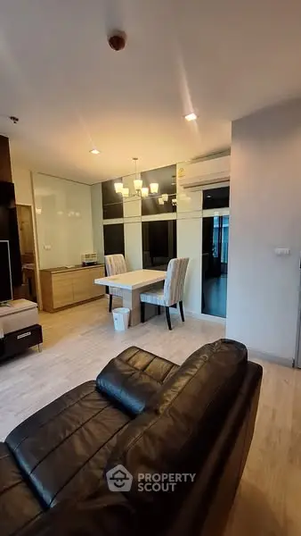Modern living room with stylish dining area and leather sofa