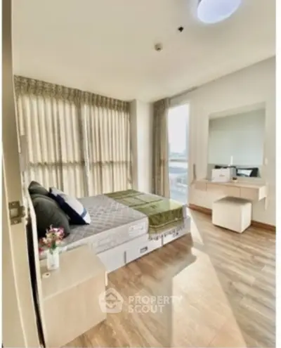 Bright and airy bedroom with large windows and modern furnishings in a stylish apartment.