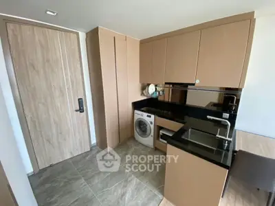 Modern compact kitchen with built-in appliances and sleek cabinetry in a stylish apartment.