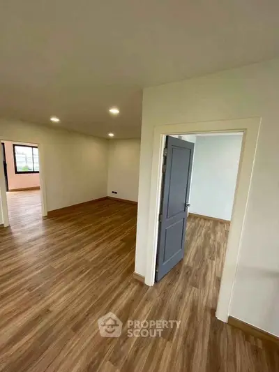 Spacious interior with wood flooring and modern lighting, ideal for versatile living spaces.