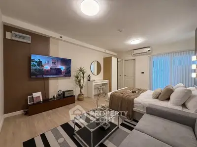 Modern living room with stylish decor, cozy sofa, and wall-mounted TV in a contemporary apartment.