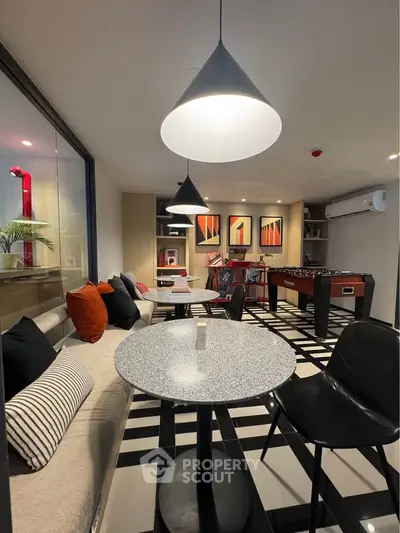 Stylish modern living room with chic decor and foosball table, perfect for entertainment and relaxation.