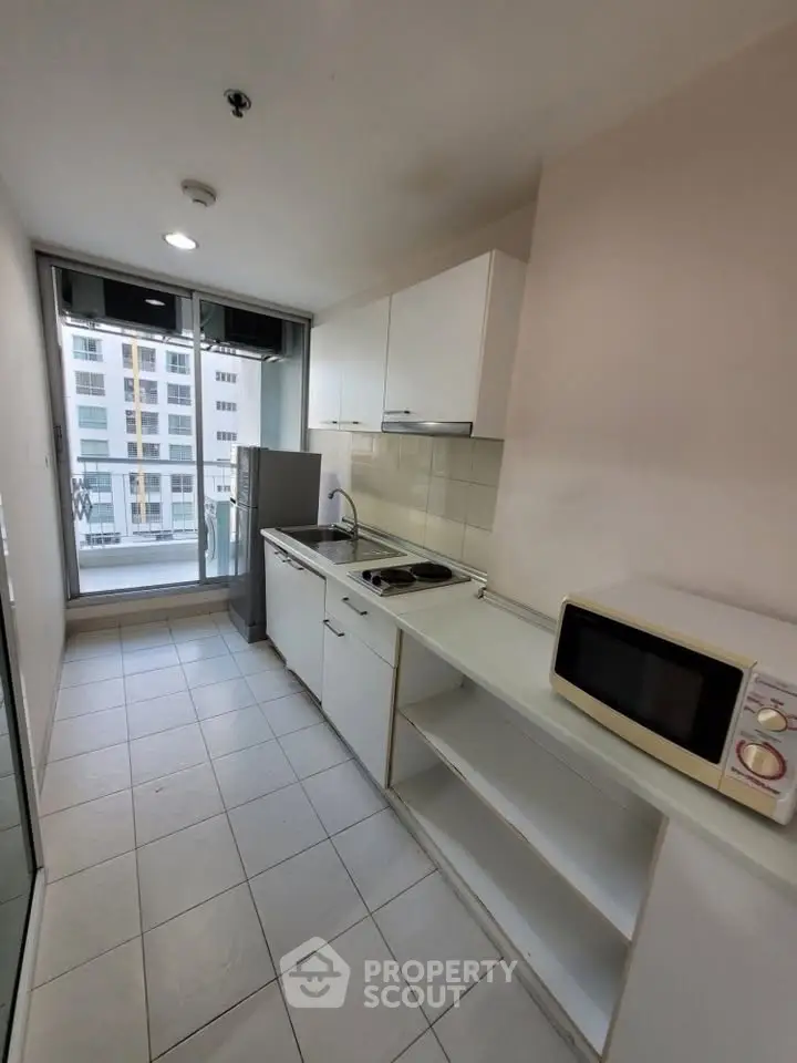 Modern kitchen with sleek appliances and city view from balcony