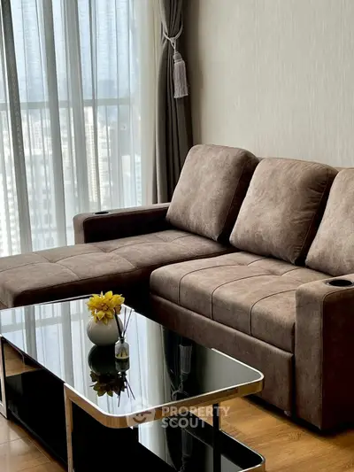 Stylish modern living room with plush brown sofa and sleek glass coffee table, perfect for urban living.