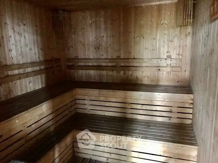 Luxurious wooden sauna room with tiered seating for ultimate relaxation.