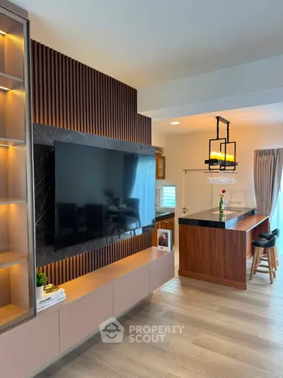 Modern living room with stylish TV setup and open kitchen layout