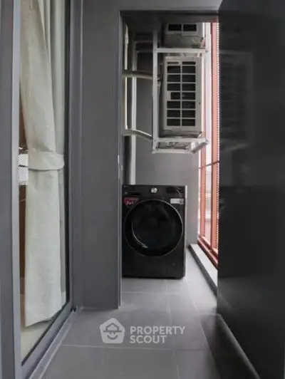 Compact balcony with washing machine and air conditioning unit in modern apartment.