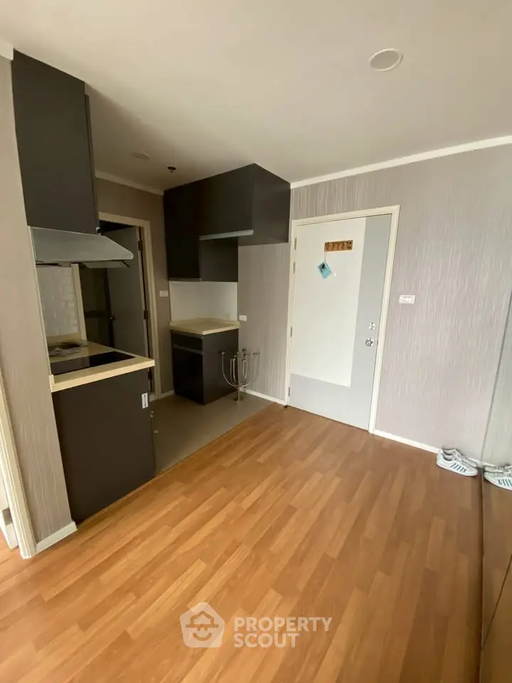 Modern kitchen with sleek cabinetry and wood flooring in a stylish apartment.
