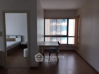 Spacious apartment with natural light and modern furnishings, featuring a cozy bedroom and open living area.