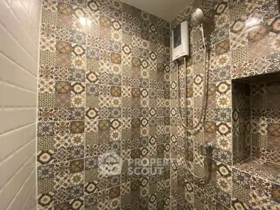 Charming bathroom with intricate patterned tiles and modern shower fixtures.