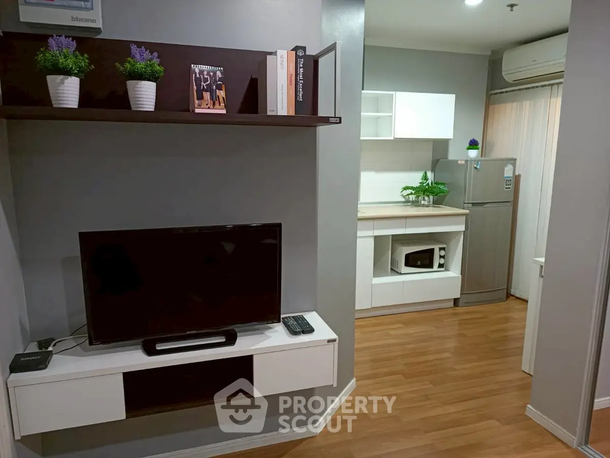 Modern apartment interior with stylish living room and kitchen, featuring wooden floors and sleek furniture.