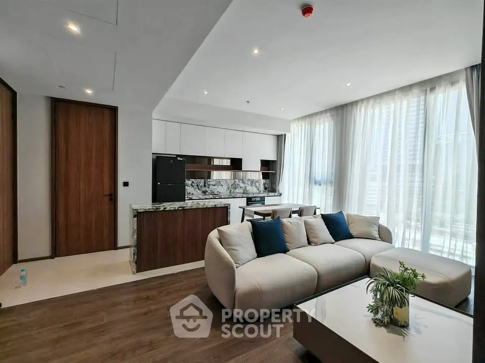 Modern living room with stylish furniture and large windows offering city views.