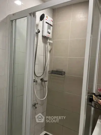 Modern bathroom with glass shower enclosure and electric water heater