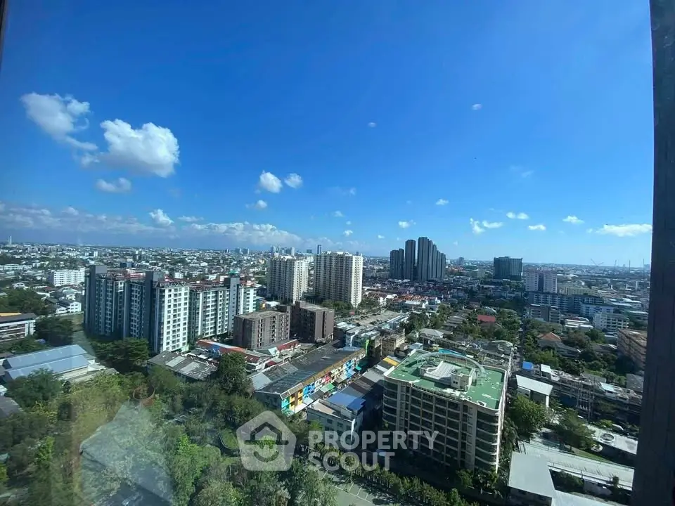 Stunning cityscape view from high-rise building with clear blue sky and urban skyline.