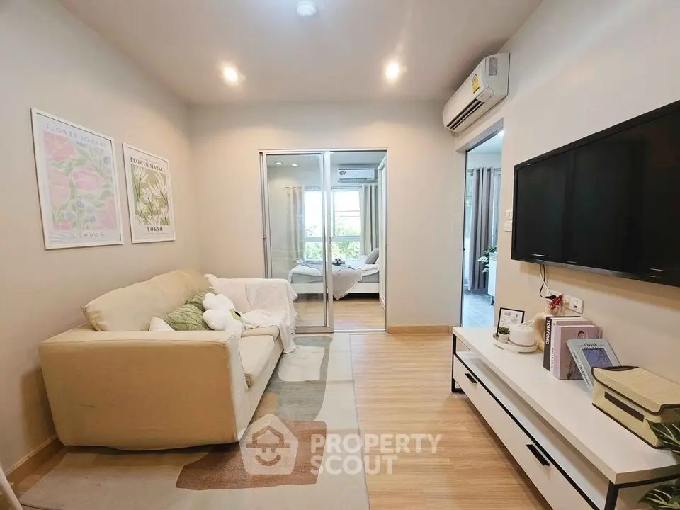 Cozy living room with modern decor and sliding glass doors leading to a bedroom, perfect for urban living.