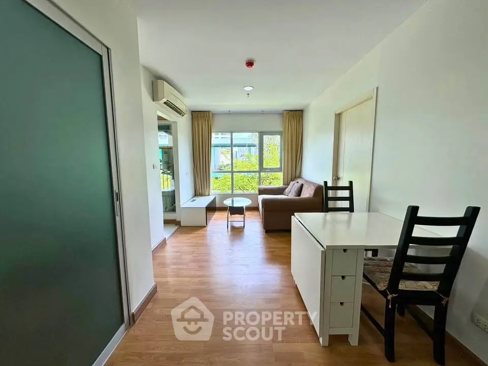 Bright and cozy living room with modern furnishings and large window view.
