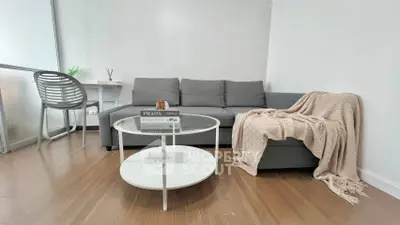Modern living room with sleek gray sofa and stylish round coffee table in a cozy apartment.
