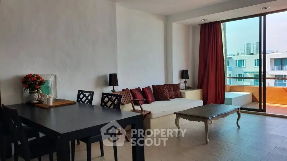 Spacious living room with elegant decor and large windows offering city views.
