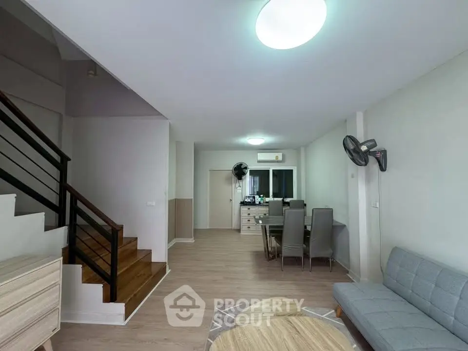 Spacious modern living room with stylish furniture and wooden staircase