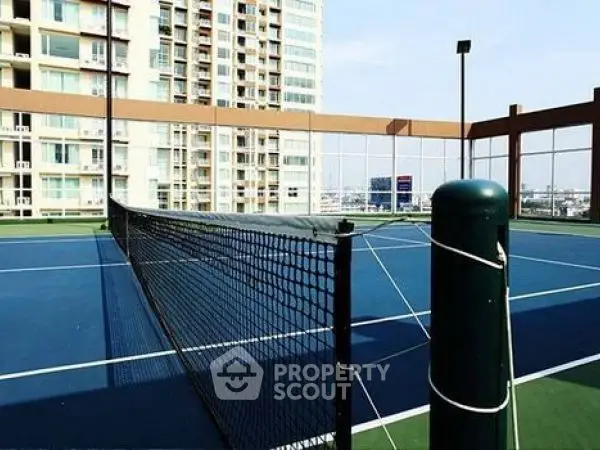 Luxurious high-rise apartment with rooftop tennis court offering stunning city views.