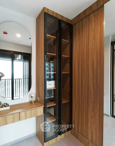 Modern bedroom with wooden wardrobe and vanity mirror, featuring sleek design and ample storage space.
