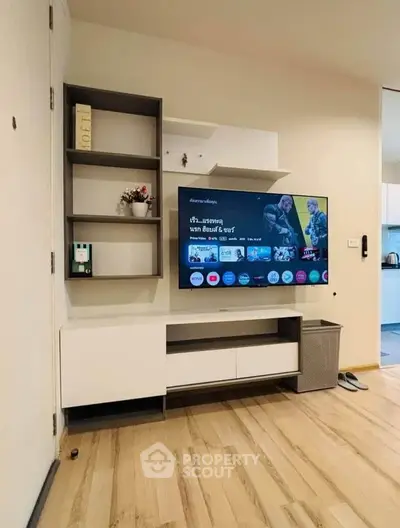Modern living room with sleek TV unit and stylish shelving in a cozy apartment.