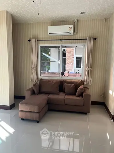 Cozy living room with stylish sofa and air conditioning, perfect for relaxation.