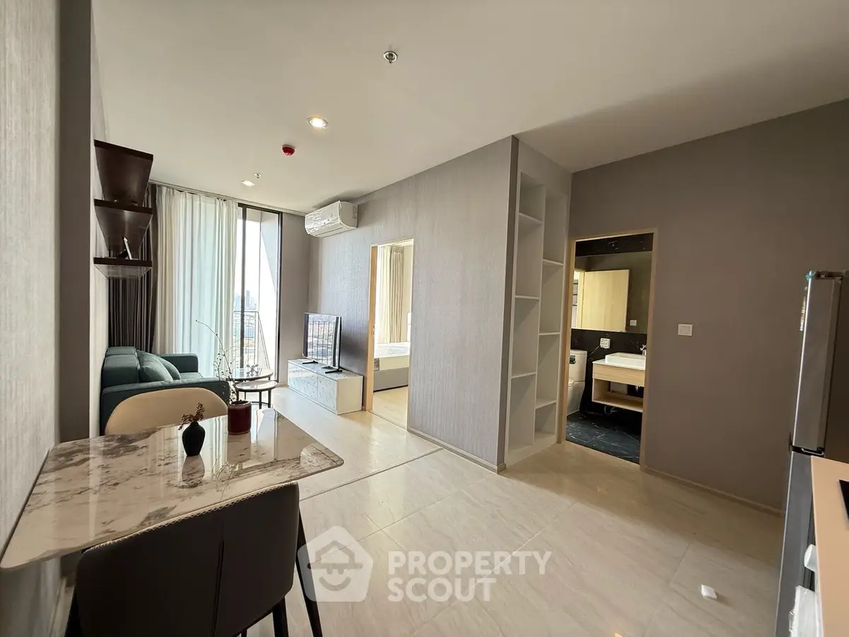 Modern open-plan living room with sleek kitchen and city view, perfect for urban living.
