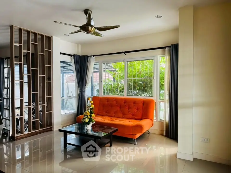 Modern living room with orange sofa and large windows for natural light